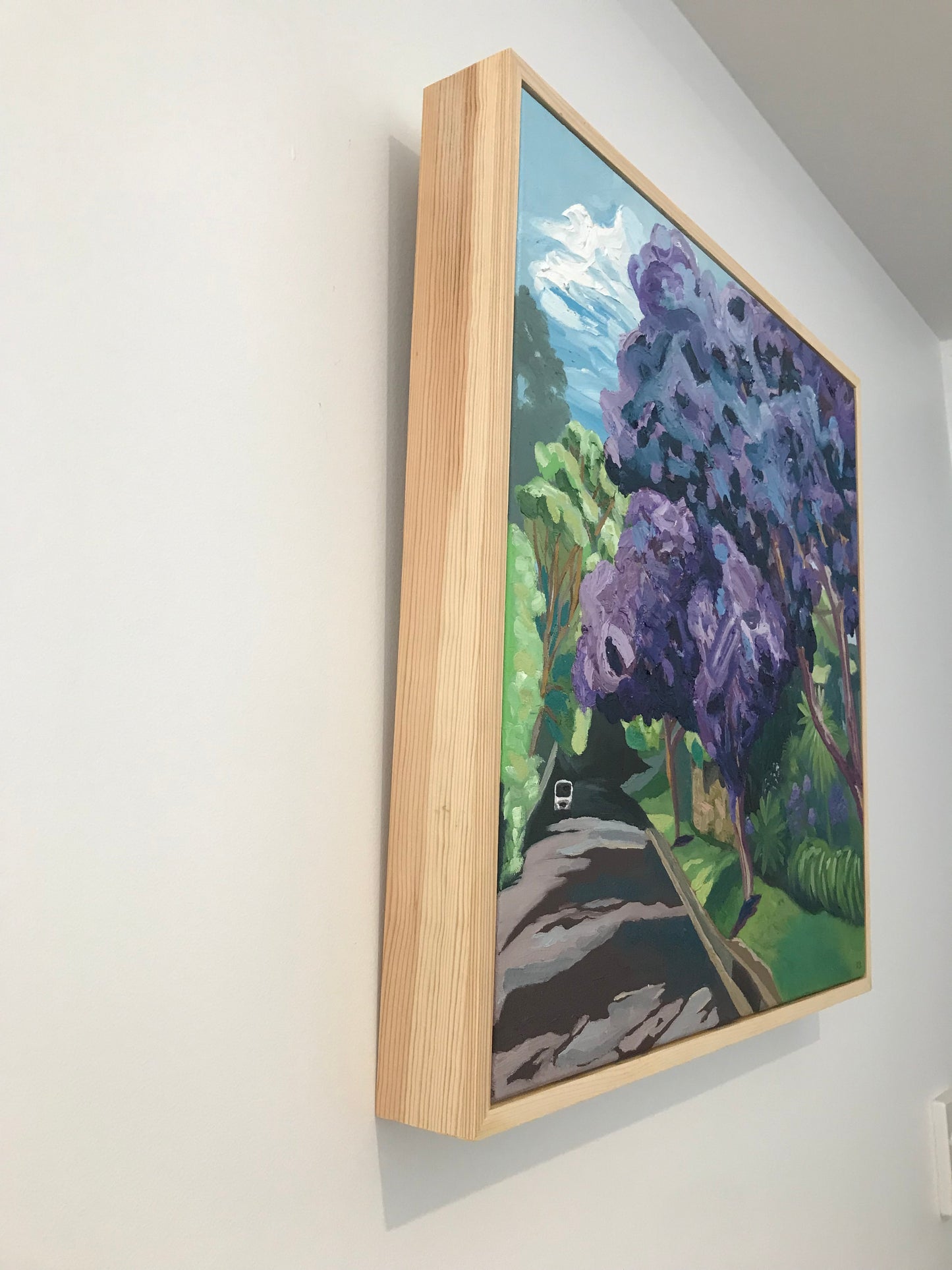 Framed artwork of purple flowers on a white surface