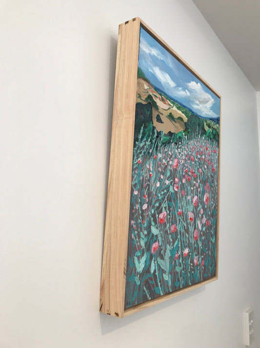 Framed artwork with a landscape scene on a white surface