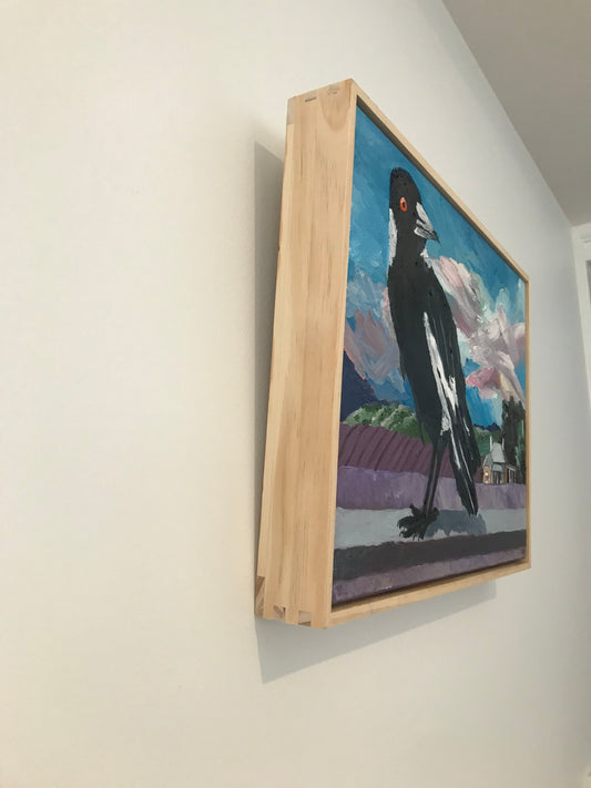 Framed artwork of a black and white bird on a colorful background