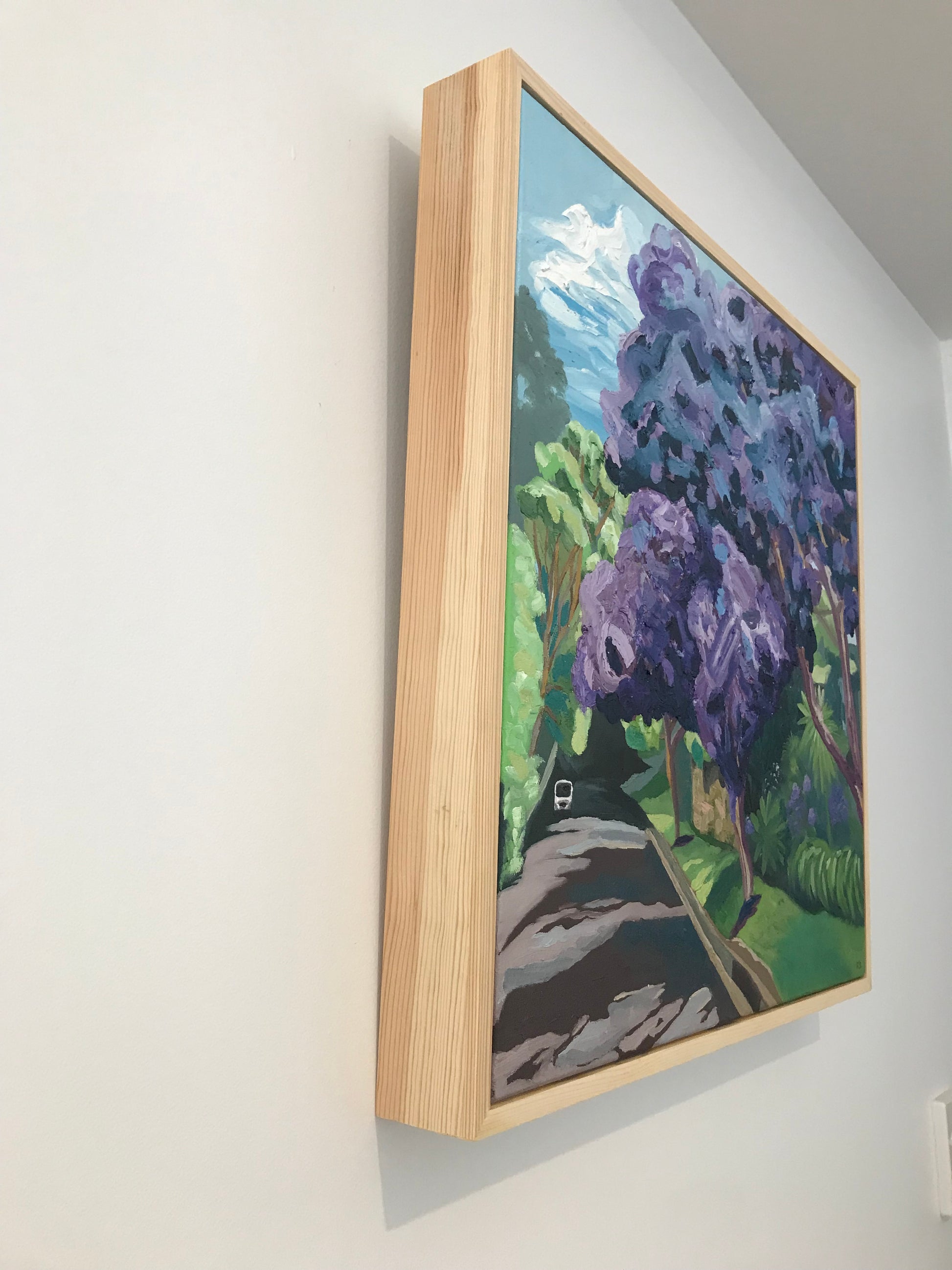 Framed artwork of purple flowers on a white surface