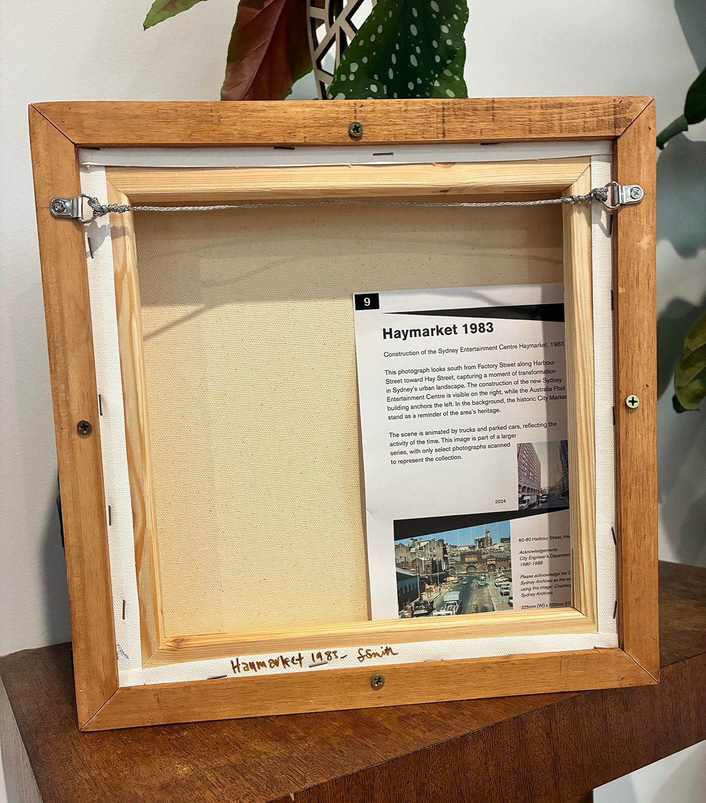 Wooden picture frame with a document inside, on a wooden surface.