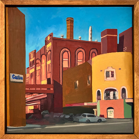 Painting of urban street scene with buildings and cars, framed in wood.