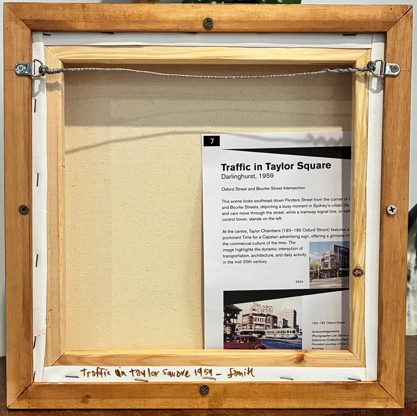 Wooden frame with a document inside, featuring text and a small image.
