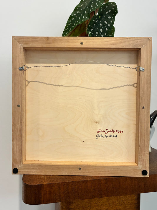 Back view of a wooden framed artwork with signature and date.