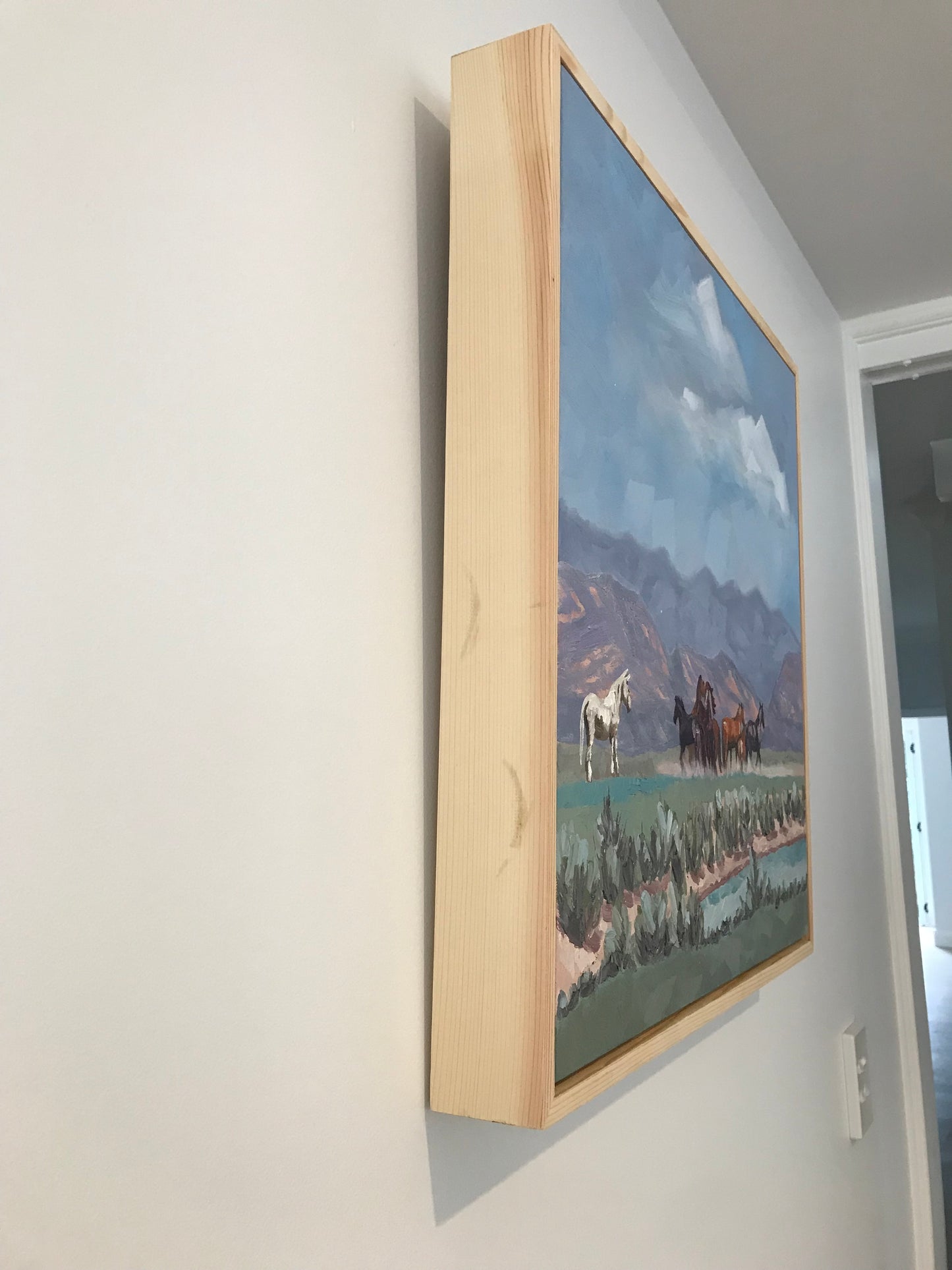 Painting in a wooden frame on a white surface